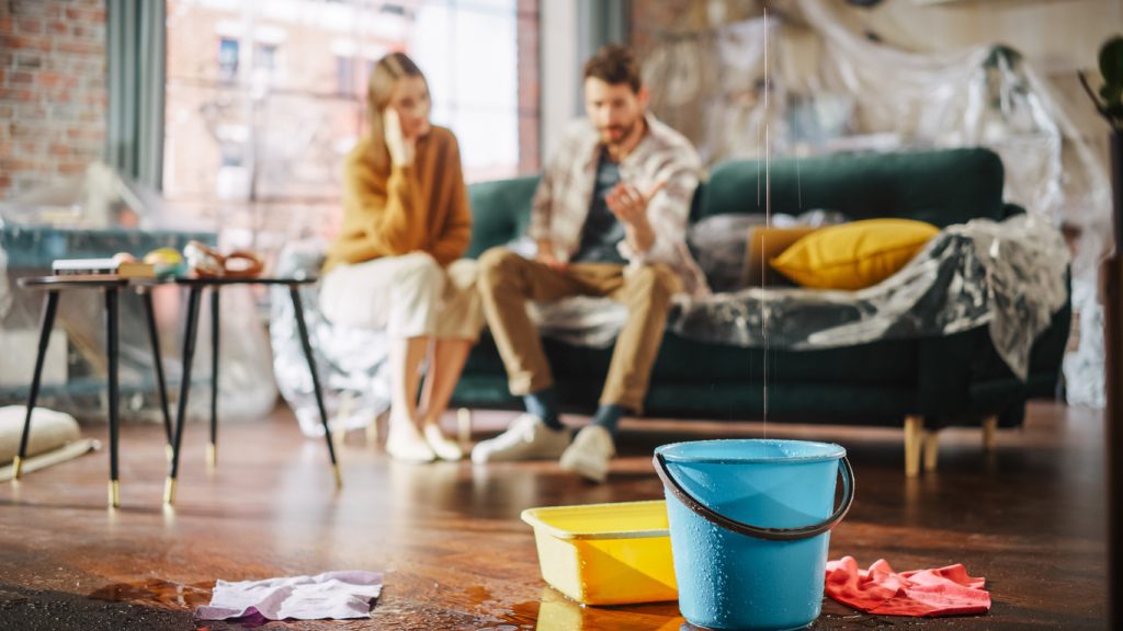Homeowners in a flooded home call a water damage restoration company